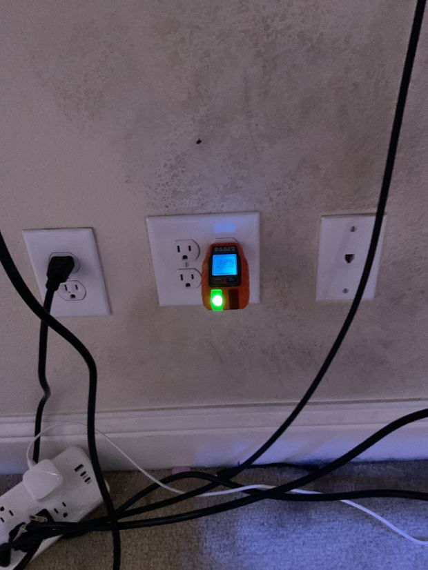New outlet tested with a meter showing 125 volts and a green pass light