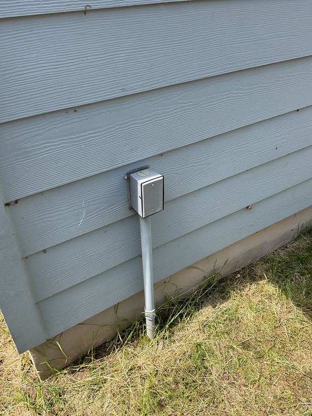 Weatherproof box on a conduit riser installed outside a Hutto home